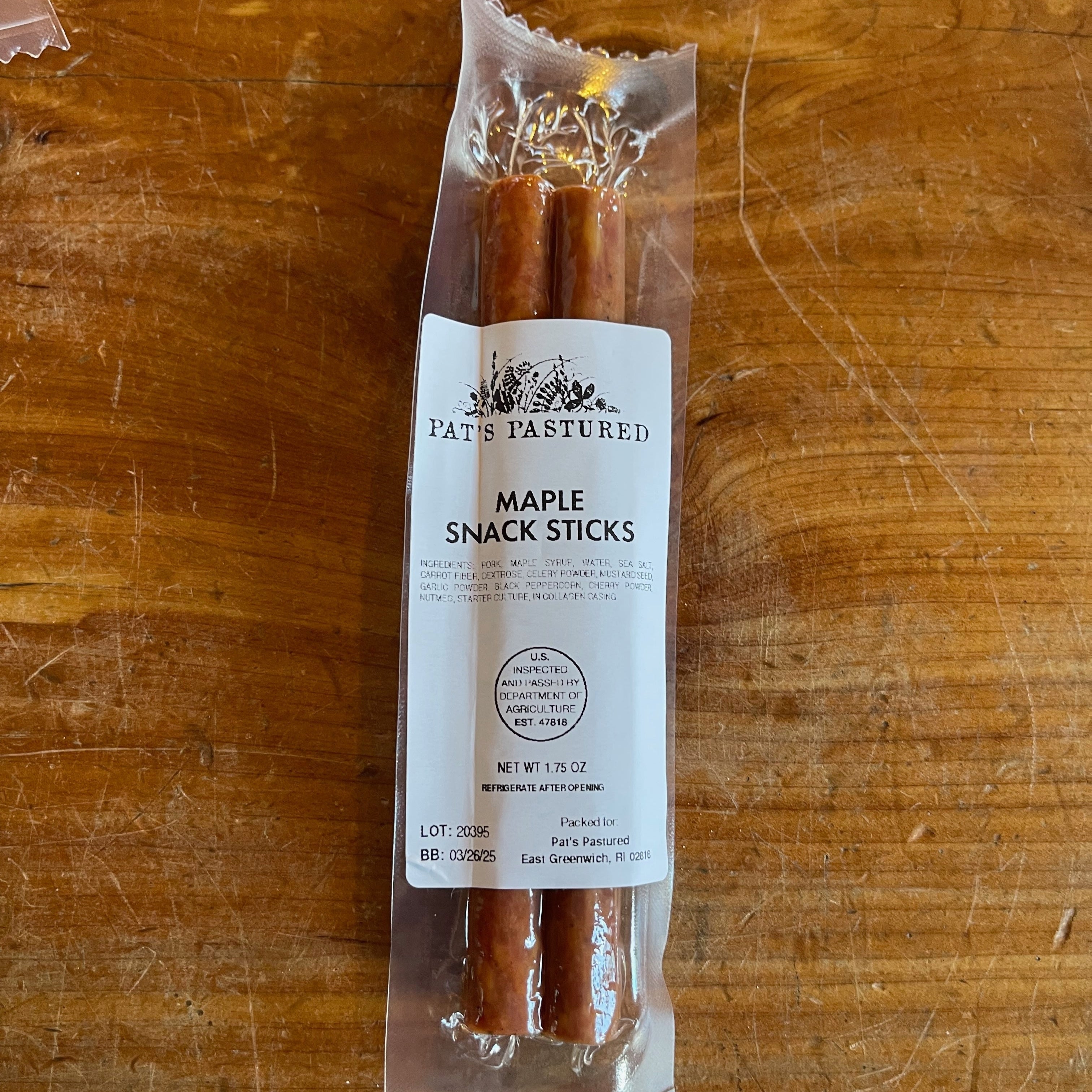Packaged Pork Maple Snack Sticks on a wooden surface