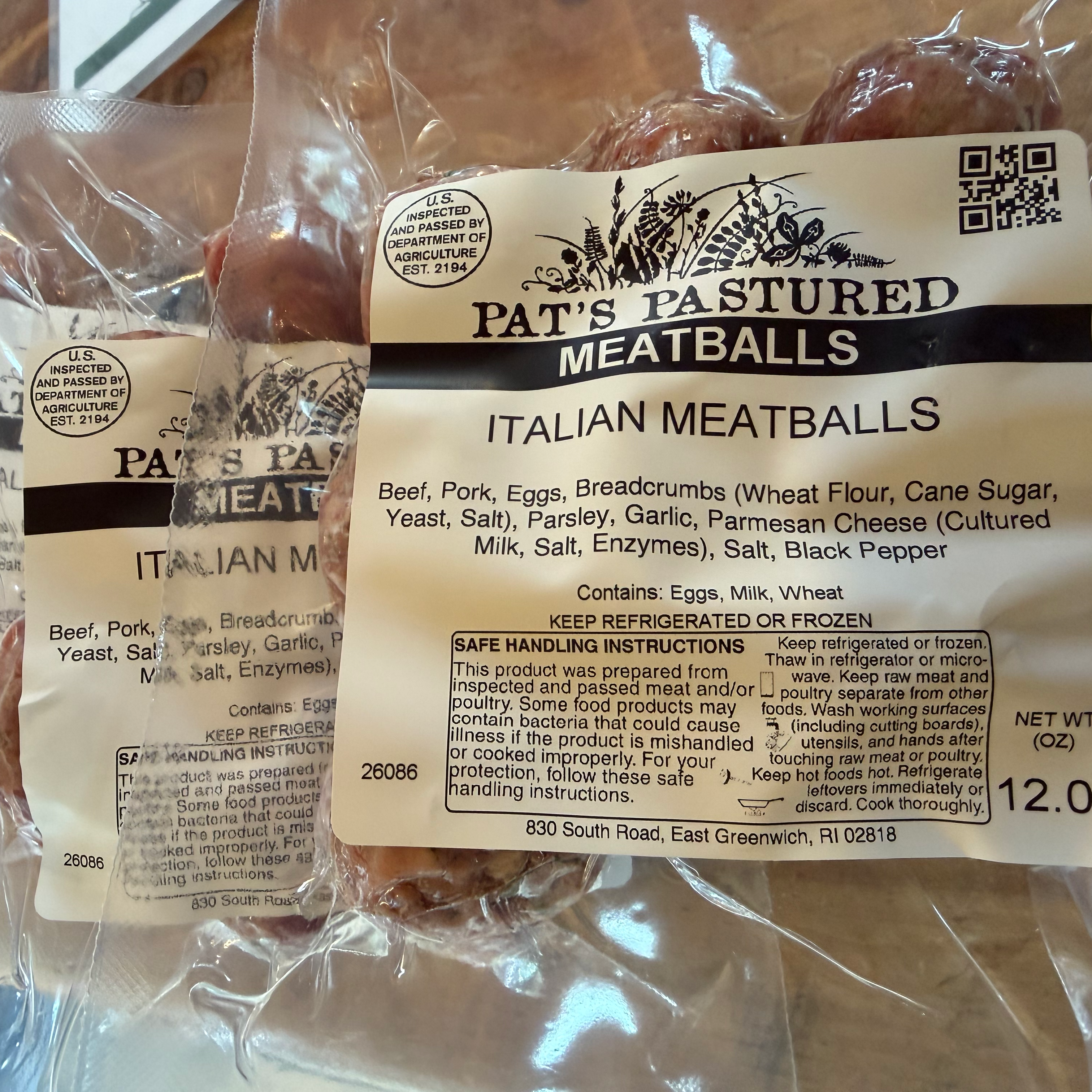 Packaged Pat's Pastured Italian Meatballs with label on a wooden surface